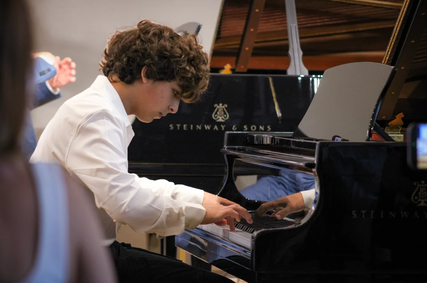 Avery Cohen playing the grand piano during the masterclass